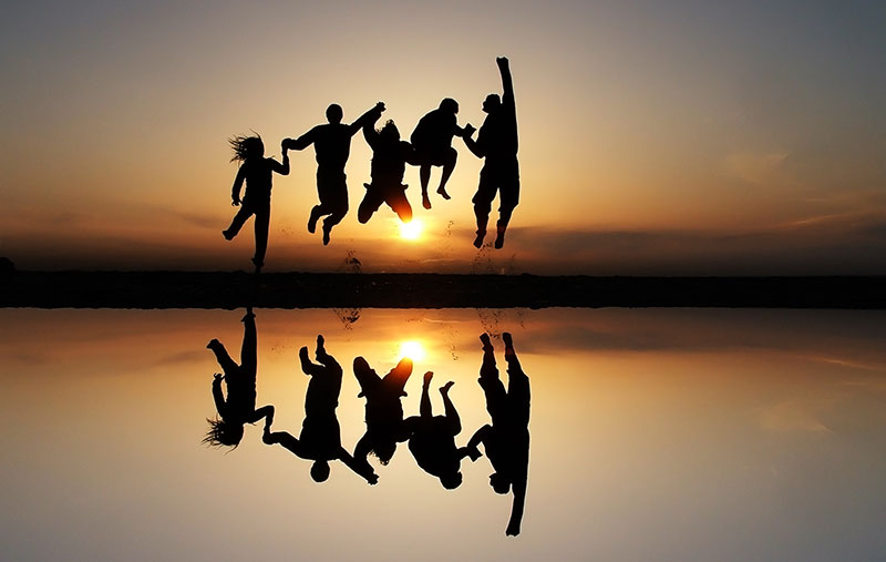 People jumping in front of a sunset