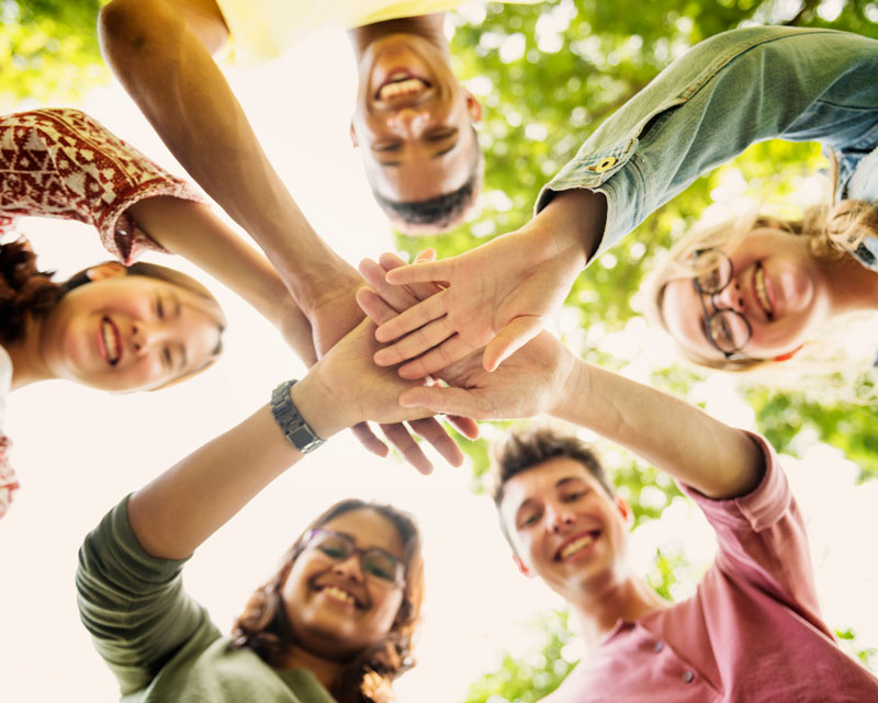 Group of people smiling with hands together