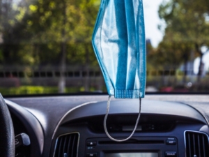 mask hanging in car from rearview mirror shows adaptability in the workplace