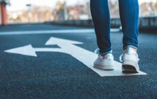 person walking on arrows that go different ways - they have to make a choice