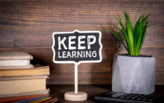 sign that says keep learning on a desk to indicate continuous improvement